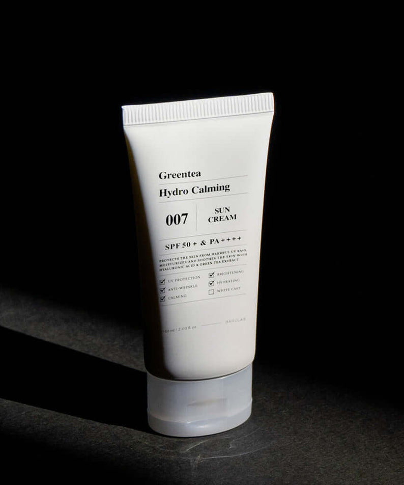 BARULAB Green Tea Hydro Calming Sun Cream in a white tube against dark background, showcasing SPF 50+ skin protection benefits.