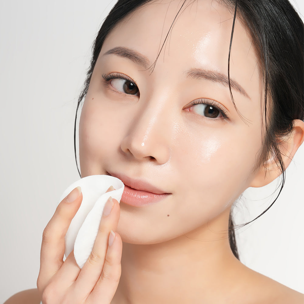 Woman using BARULAB Rice Bran Ceramide Cream In Cleansing Pads 30 sheets on her face for gentle cleansing and hydration.
