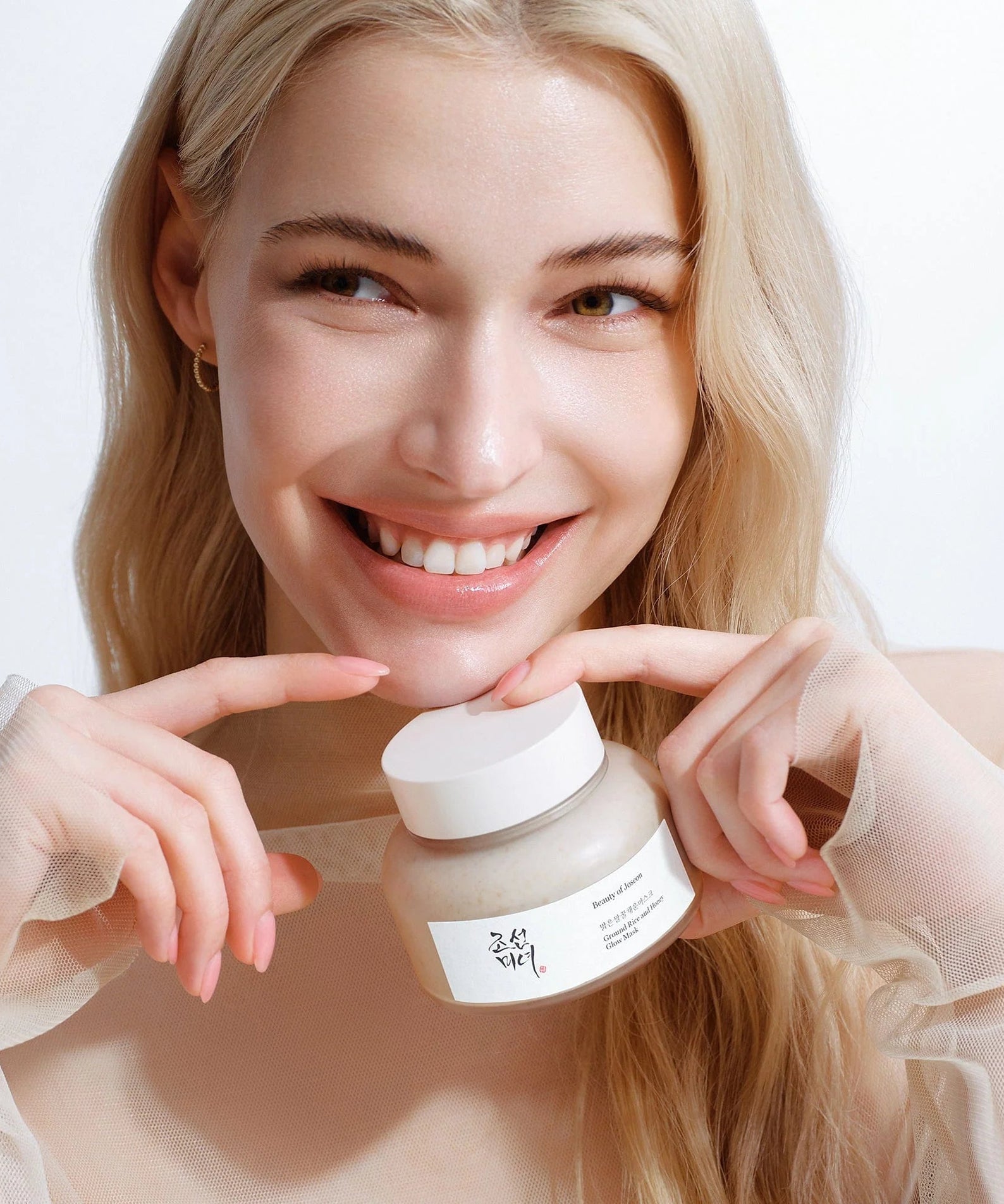 Woman holding BEAUTY OF JOSEON Ground Rice and Honey Glow Mask 150ml with a smile