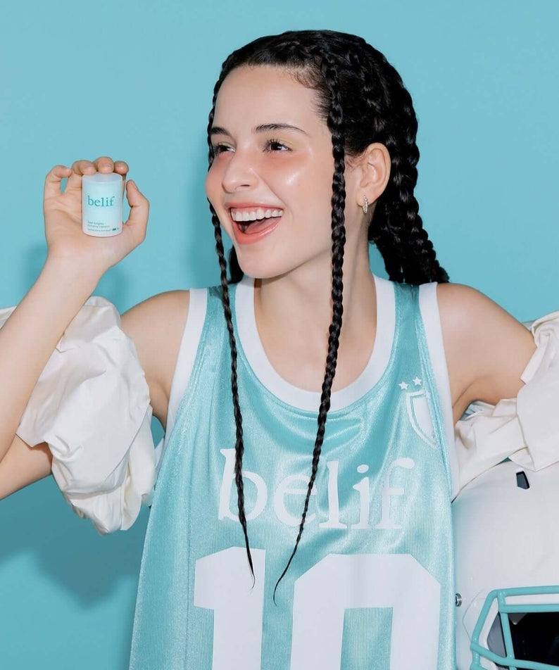 BELIF Super Knight Mint Plumping Lipcerine held by a person in a sports jersey, smiling against a blue background.