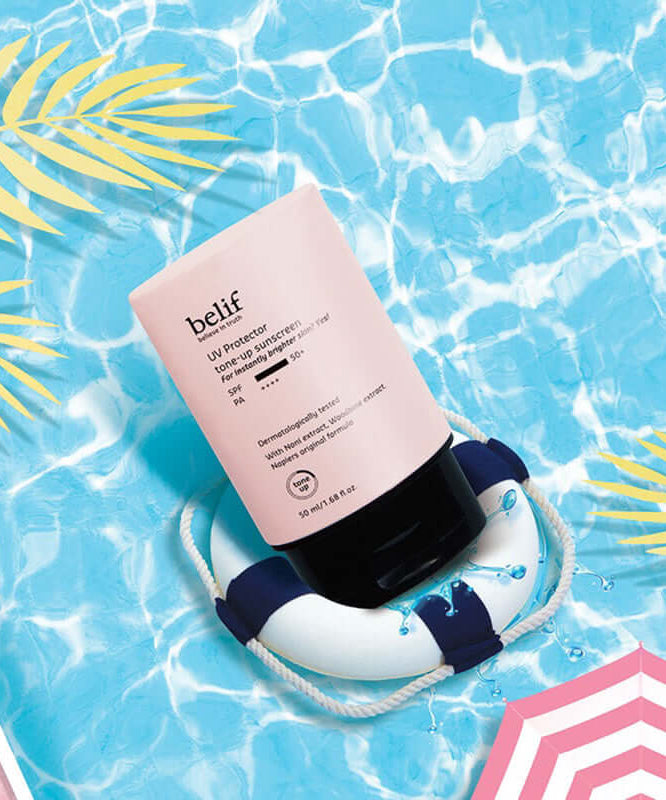 BELIF UV Protector Tone-up Sunscreen 50ml floating in pool with tropical design