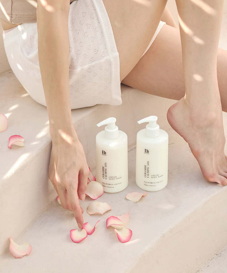 BENTON Ceramide Calming Ato Cream Body Wash 300ml placed on steps with pink rose petals