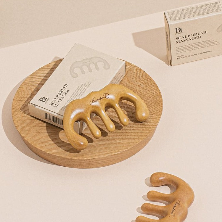 BENTON Scalp Brush Massager on wooden tray with packaging in a minimalist setting