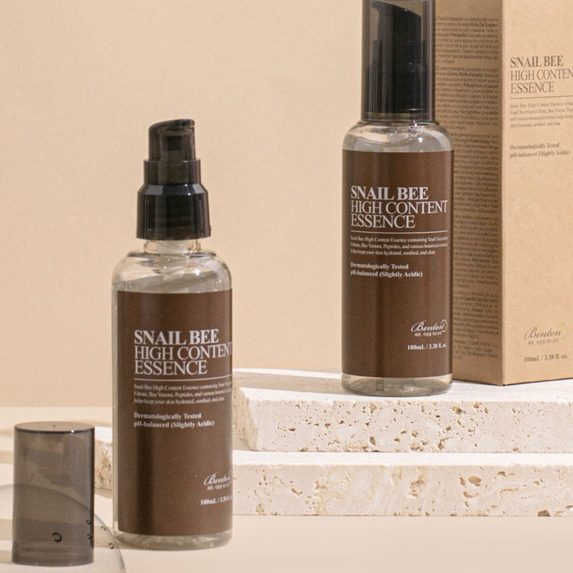BENTON Snail Bee High Content Essence 100ml skincare bottles on a stone surface