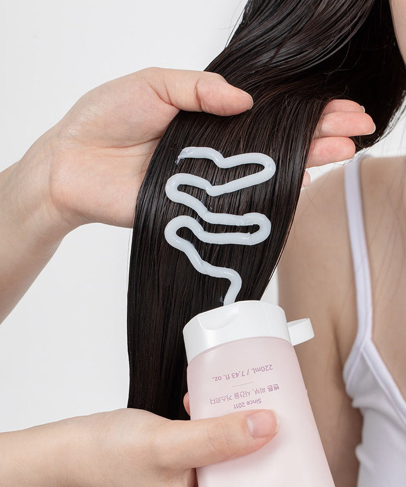 Applying BENTON Glycine Protein Deep Conditioning Hair Mask 220ml to dark hair for nourishment and shine.