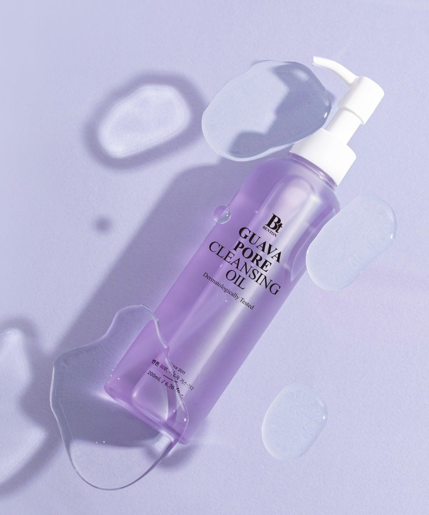BENTON Guava Blackhead Pore Cleansing Oil 200ml bottle with purple liquid and pump on a light purple background