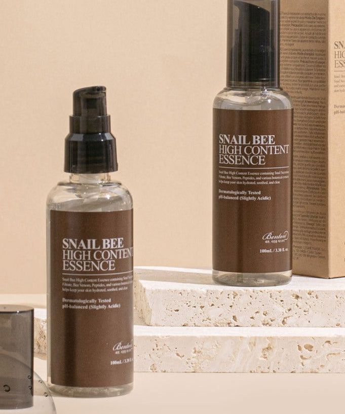 BENTON Snail Bee High Content Essence 100ml skincare bottles on a stone surface