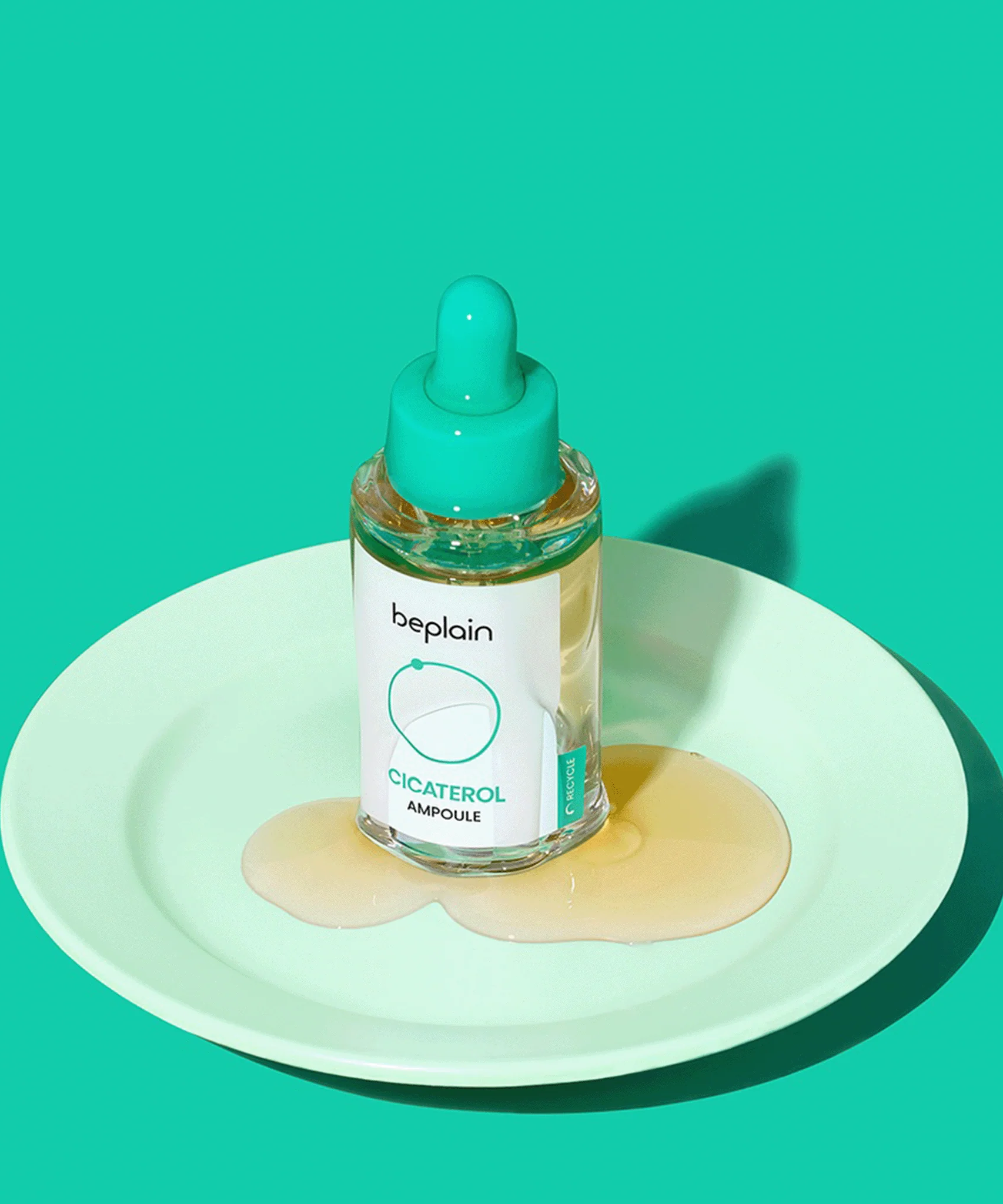 BEPLAIN Cicaterol Ampoule 30ml on a plate with product spillage, showcasing skincare product packaging.