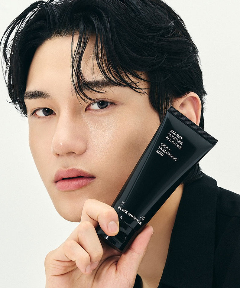 Gentleman Korea product shot: BLACK MONSTER All-Day Moisturizing All-in-One held by male model, sleek black tube for men’s Korean skincare