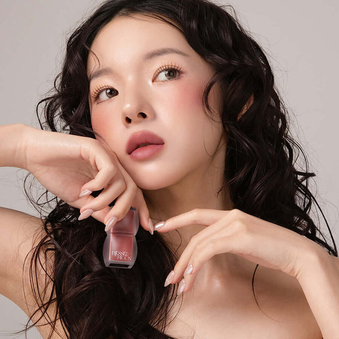 Model holding BLESSED MOON Veil Blur Lip Tint in a neutral makeup look
