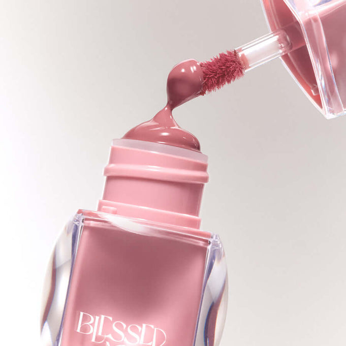 BLESSED MOON Veil Glow Lip Tint with applicator showing a rich pink color and glossy finish.