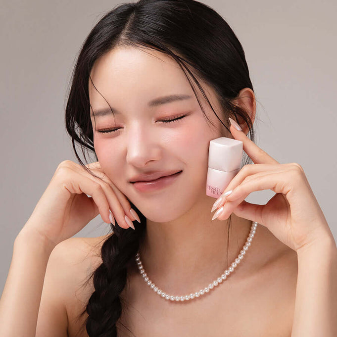 Woman smiling while holding BLESSED MOON Veil Melting Color Blush, showcasing its elegance and vibrant color payoff.