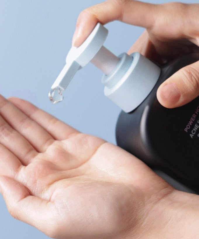 Applying BRTC Power Homme Acne Solution Body Wash 500ml onto hand for skincare.