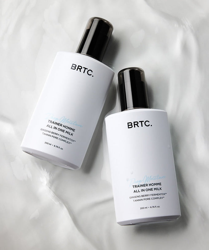Two bottles of BRTC Trainer Homme ALl-in-One Milk 200ml on a white surface, highlighting skincare benefits for men.