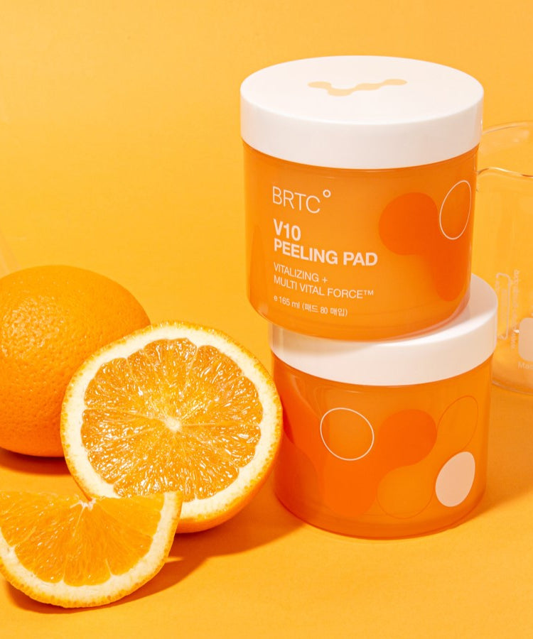 BRTC V10 Peeling Pad 80pcs 165ml displayed with fresh oranges and laboratory beakers on an orange background