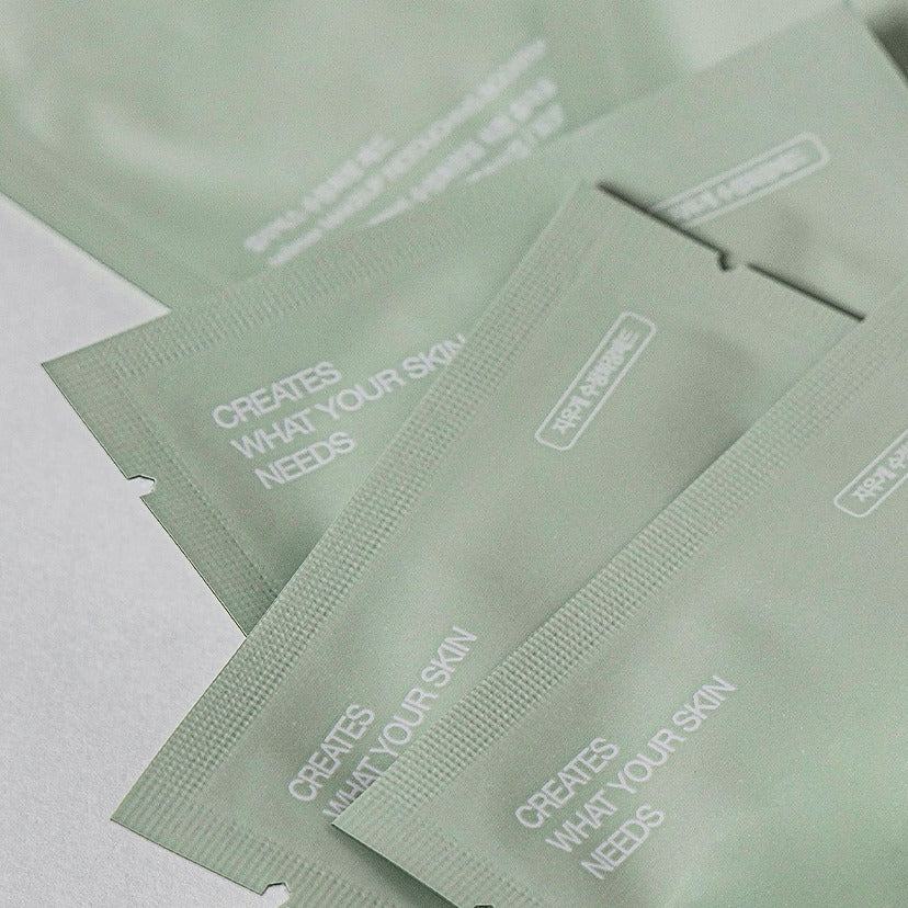 Close-up of CELIMAX 30 Corrective Makeup Pads packaging showing the text 'CREATES WHAT YOUR SKIN NEEDS' on green packets.