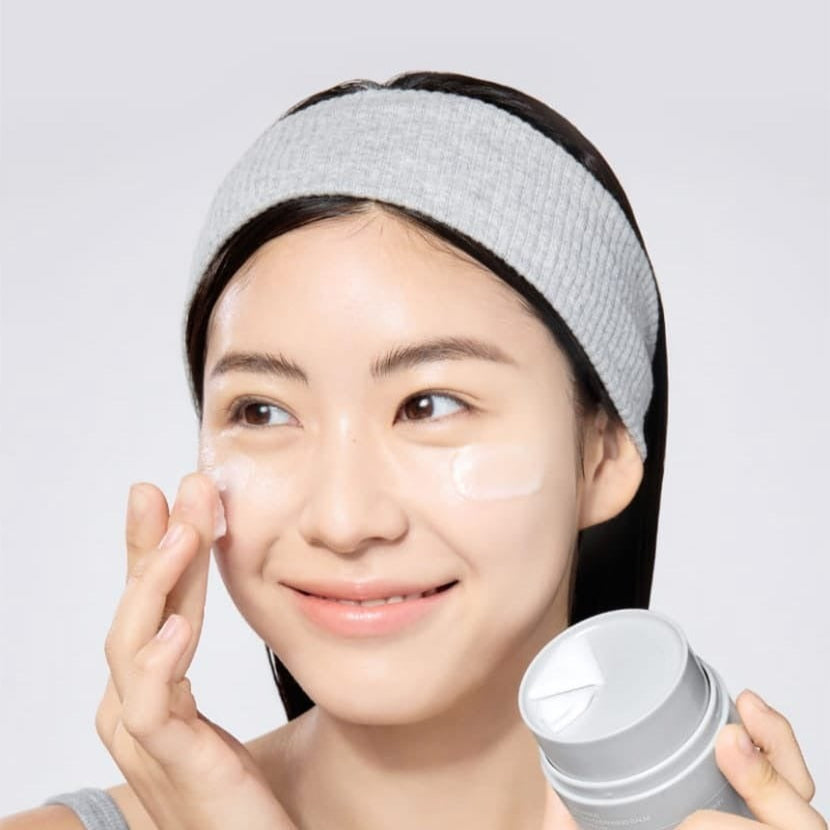 Woman applying CELIMAX Dual Barrier Purifying Cleansing Balm 50ml to her face for skincare routine.