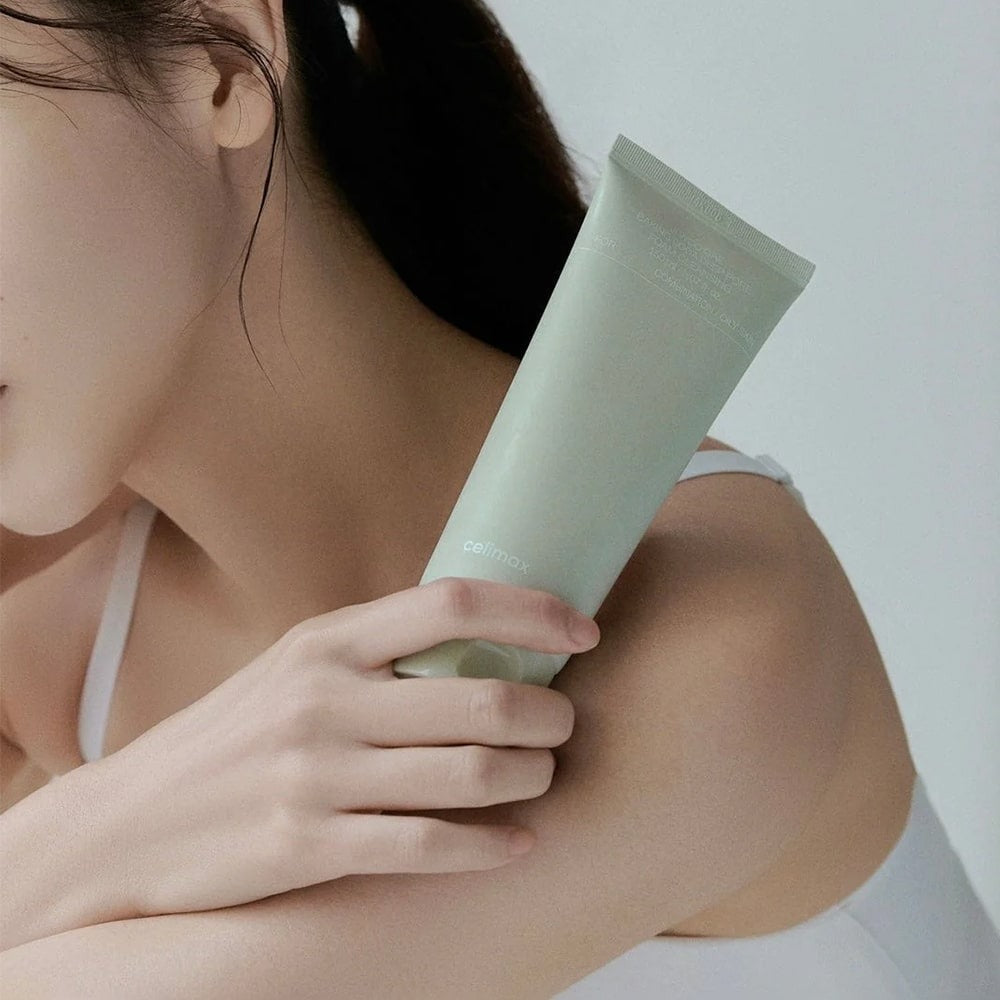 Woman holding a tube of CELIMAX Ji Woo Gae Baking Soda Deep Pore Foam Cleansing 150ml