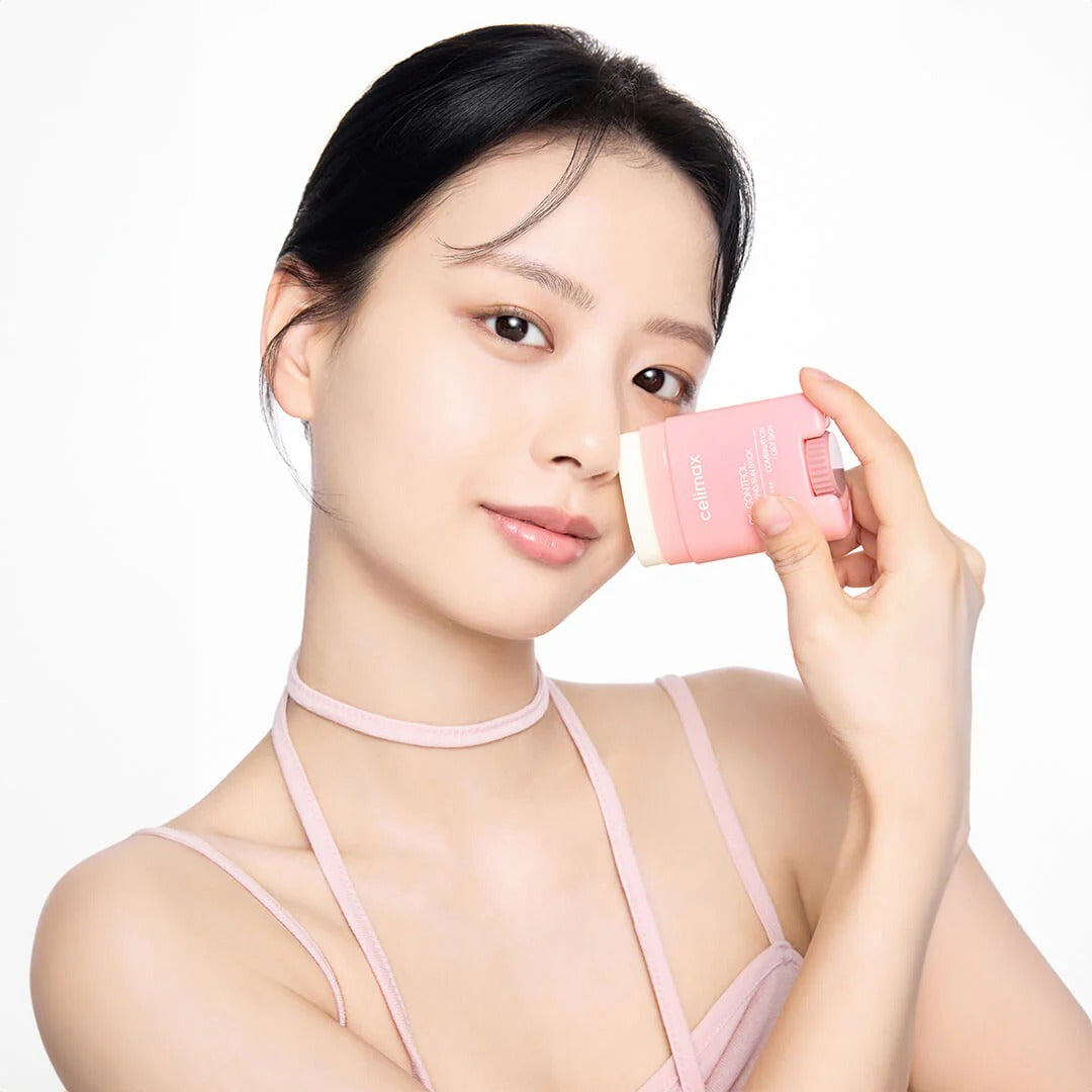 Woman holding CELIMAX Oil Control Sun Stickk 19g near her face