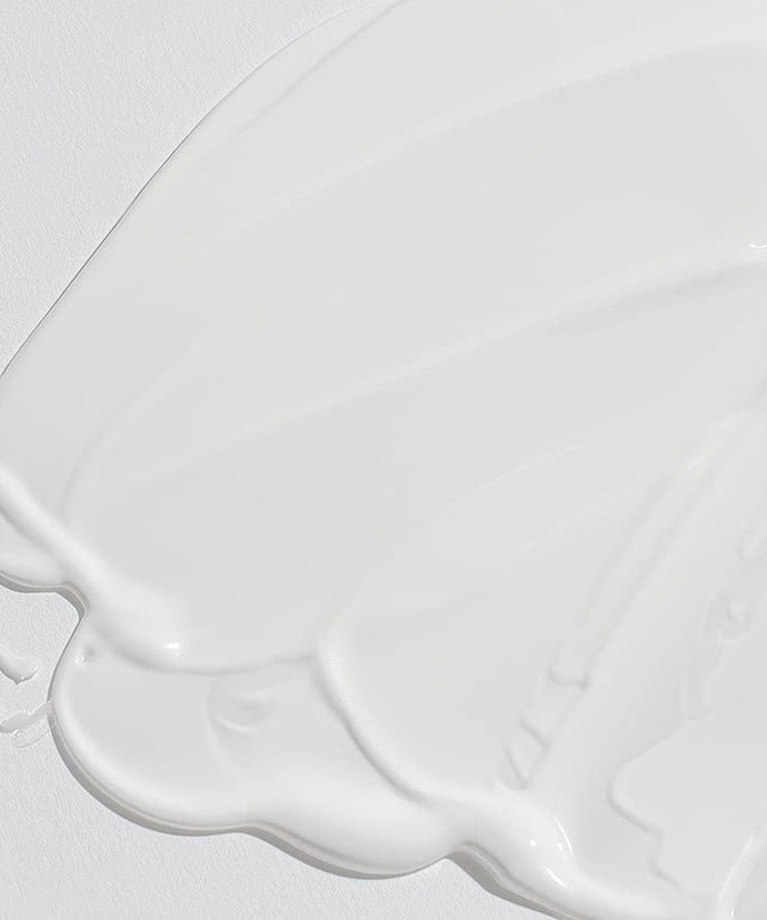 Texture of CELIMAX Dual Barrier Watery Sun Cream 40ml on a white surface, showcasing its rich, smooth consistency for skincare enthusiasts.