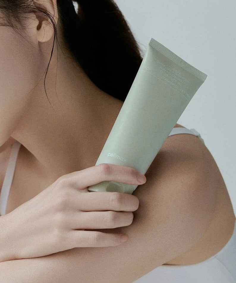 Woman holding a tube of CELIMAX Ji Woo Gae Baking Soda Deep Pore Foam Cleansing 150ml