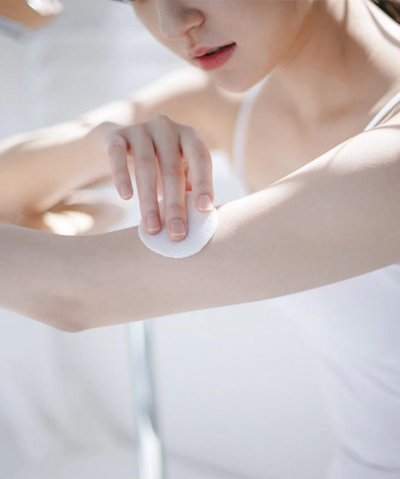 Using CELIMAX Ji Woo Gae One Step Body Brightening Pad 60 Pads on arm for skin care