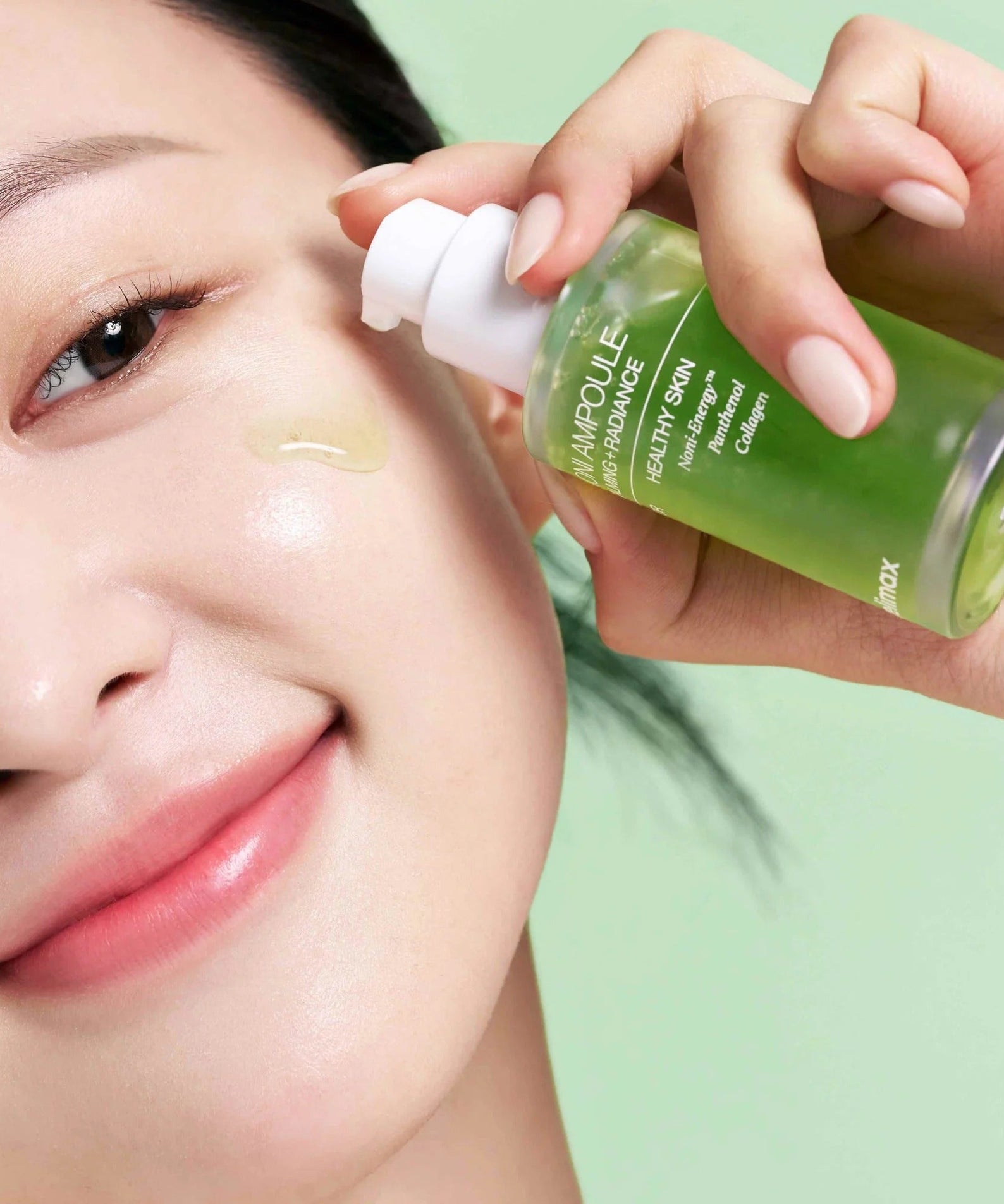 Woman applying CELIMAX Noni Ampoule Calming+Radiance 30ml to her face for skincare routine.