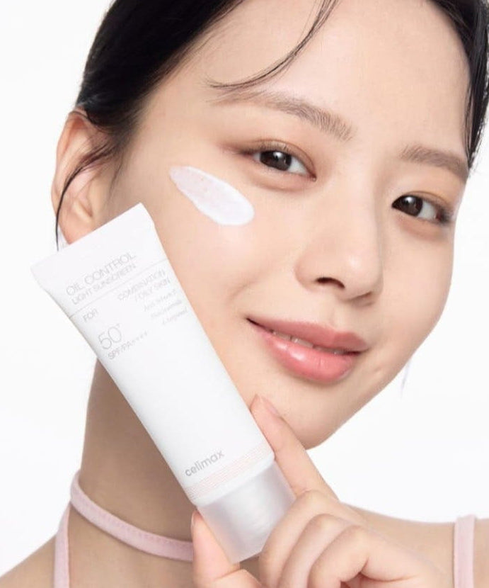 Person applying CELIMAX Oil Control Light Sunscreen 40ml with SPF 50 to face for sun protection and oil control.