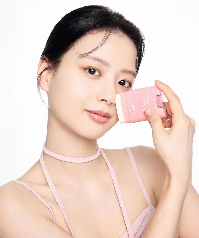 Woman holding CELIMAX Oil Control Sun Stickk 19g near her face
