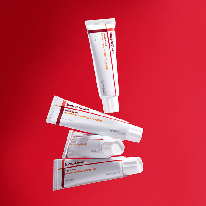 CENTELLIAN 24 Madeca Cream Time Reverse 50ml skincare tubes on red background.