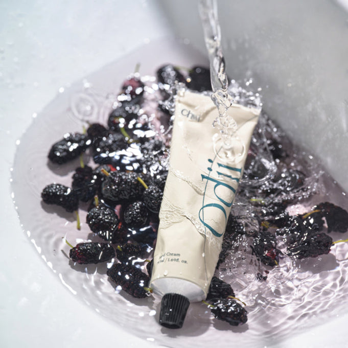 CHWI (CHI) Odii Hand Cream 50ml tube with flowing water, surrounded by fresh berries, highlighting the moisturizing blend and fragrance.