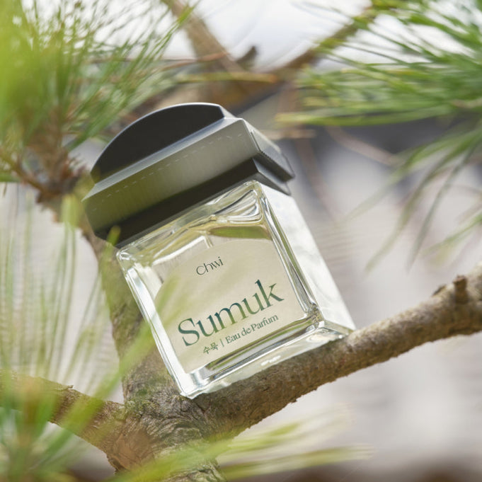 CHWI (CHI) Sumuk Parfume 50ml bottle resting on a tree branch, capturing its elegant design and natural setting.