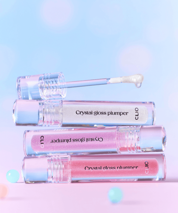CLIO Crystal Gloss Plumper stacked tubes with applicator on pastel background, showcasing glossy finish and plumping effect.