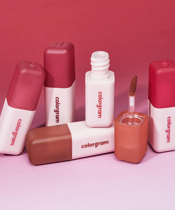 COLORGRAM Nude Blur Tint lip products on a pink gradient background, showcasing various shades and textures.