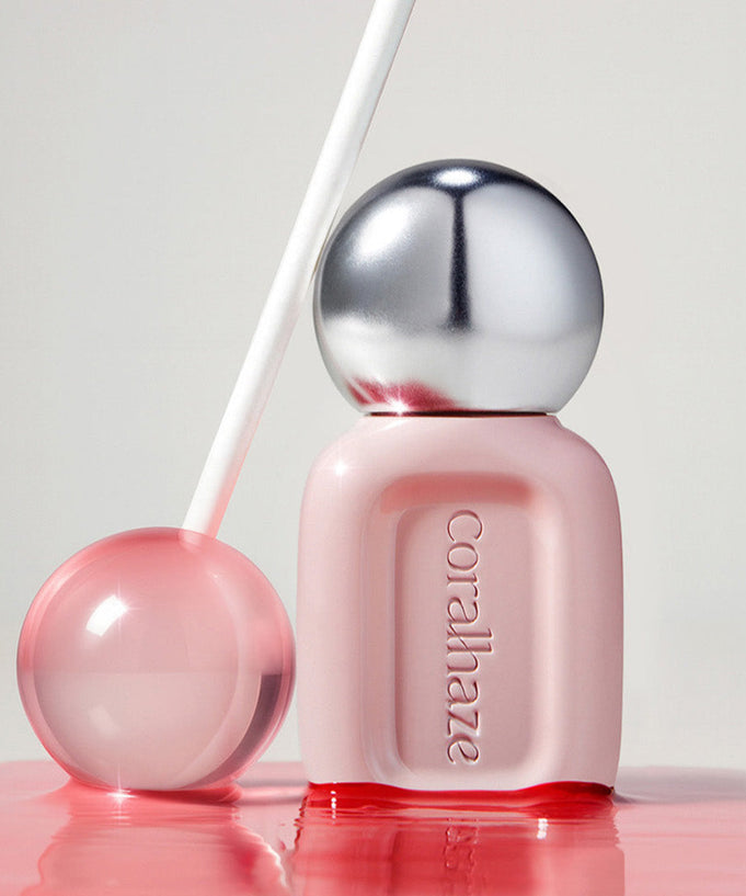 CORALHAZE Dew Drop Tint 4.5g in a sleek pink and silver bottle with a clear lollipop-like sphere, set against a soft background.