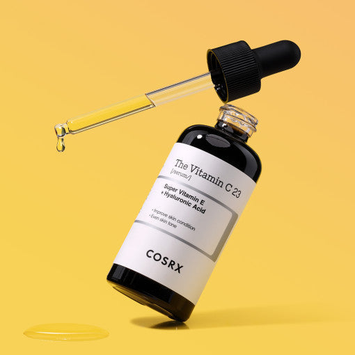 COSRX The Vitamin C 23 Serum 20ml bottle with dropper on a yellow background