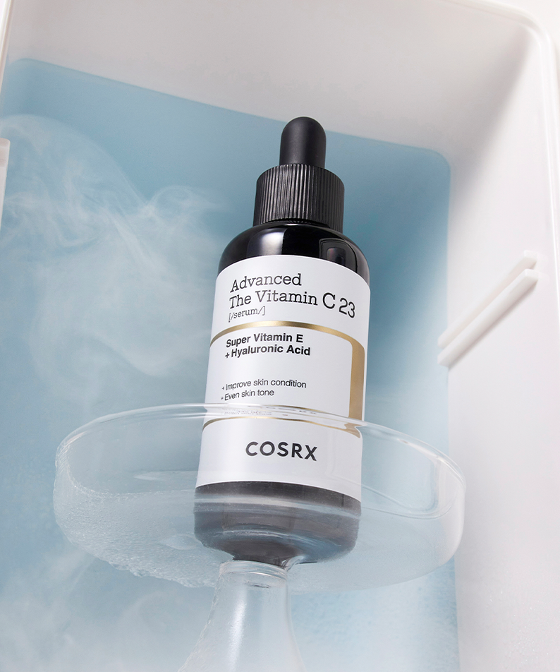 Bottle of COSRX Advanced The Vitamin C 23 Serum with dropper on a blue background in a skincare display