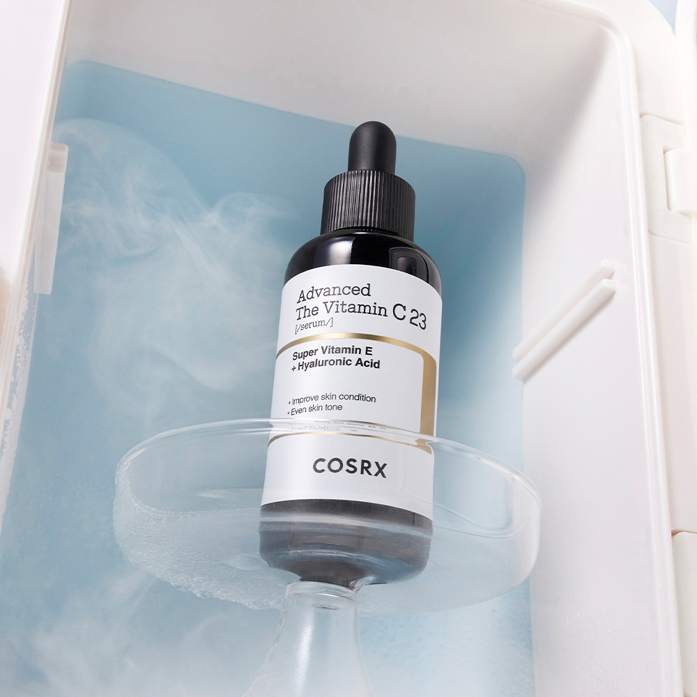 Bottle of COSRX Advanced The Vitamin C 23 Serum with dropper on a blue background in a skincare display