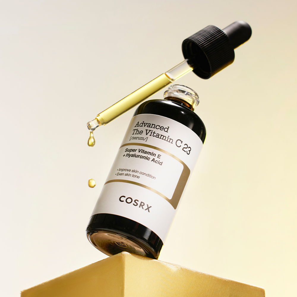 Bottle of COSRX Advanced The Vitamin C 23 Serum with dropper on yellow background