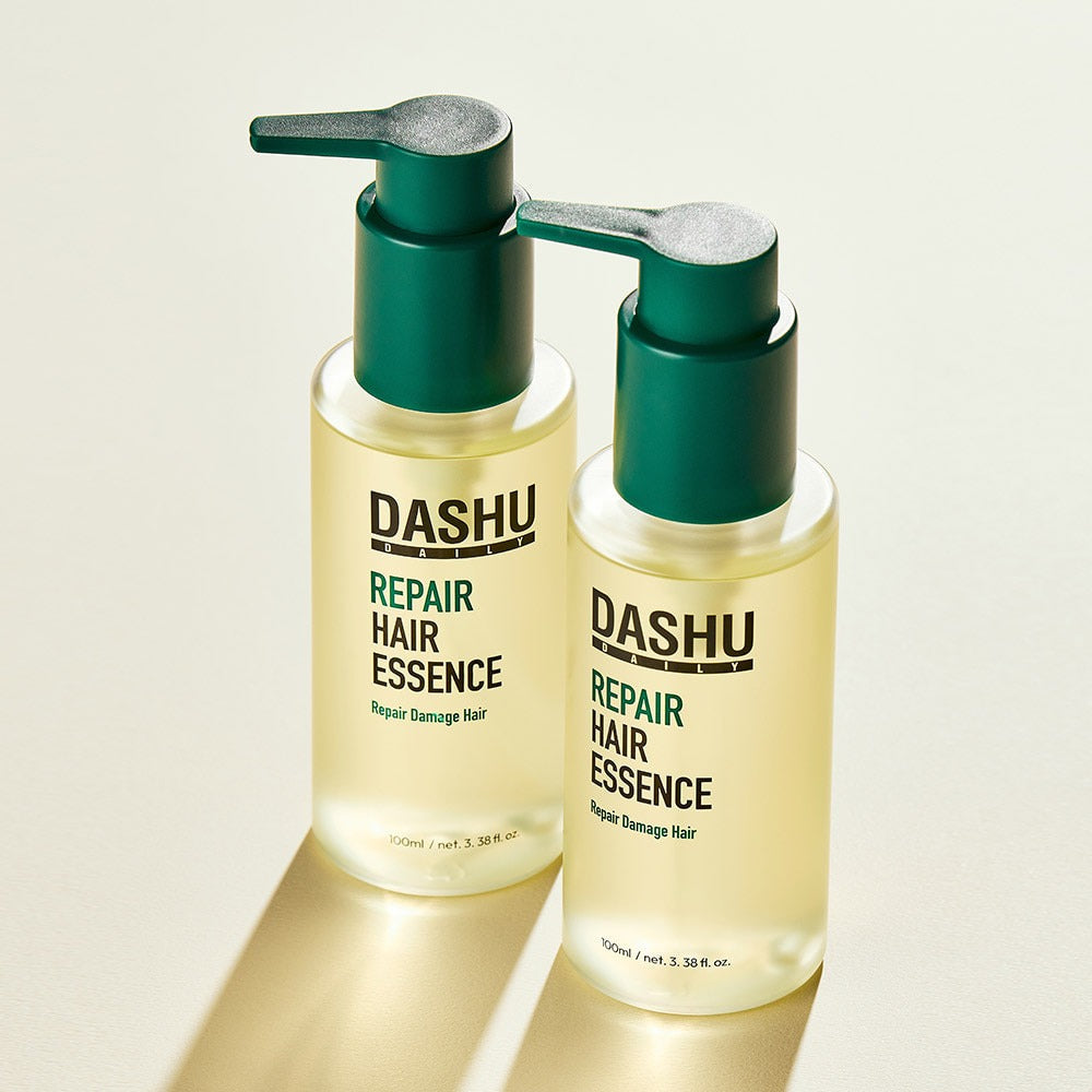 Two bottles of DASHU Daily Repair Hair Essence 100ml with pump dispensers displayed on a light background.
