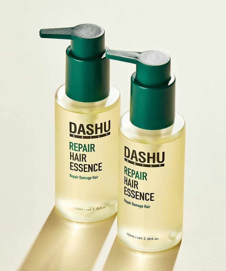Two bottles of DASHU Daily Repair Hair Essence 100ml with pump dispensers displayed on a light background.