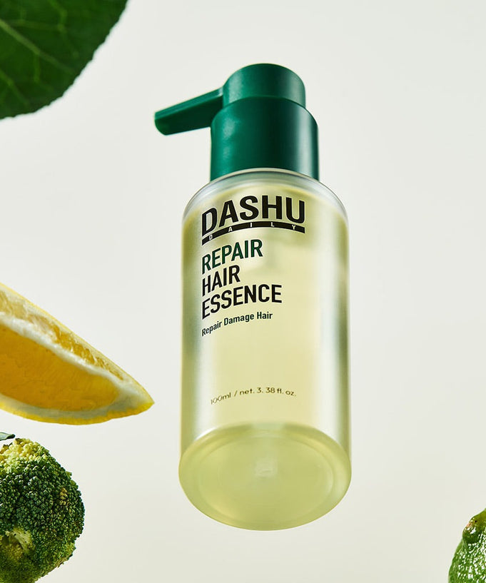 DASHU Daily Repair Hair Essence 100ml bottle with natural ingredients like lemon and broccoli for hair repair and nourishment.