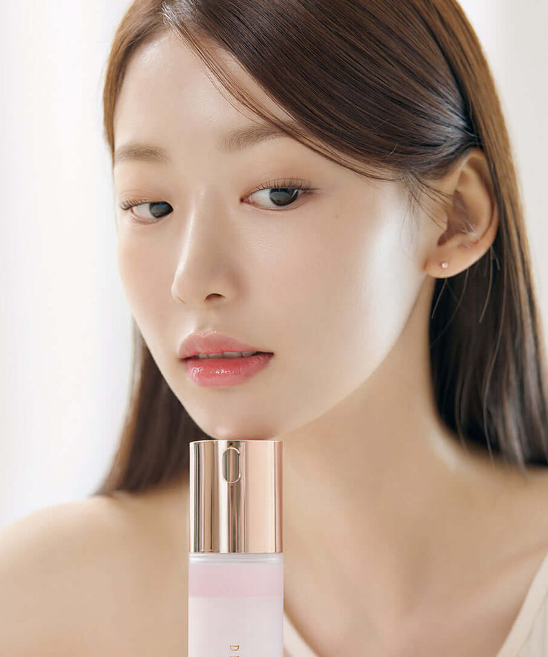 Woman holding DEAR DAHLIA Endless Skin Cream Mist bottle