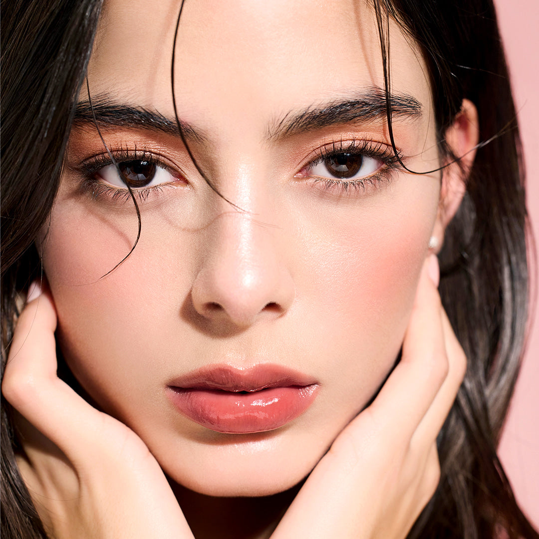 Model wearing DEAR DAHLIA Lip Paradise Sensual Lip Glow with glossy finish.
