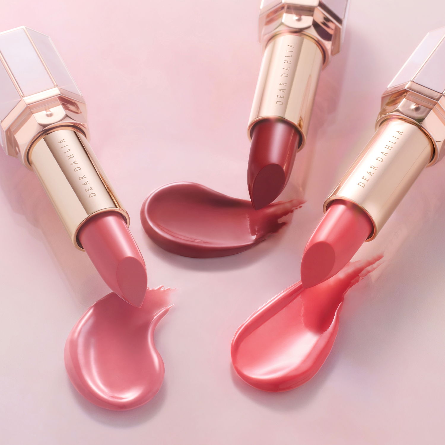 DEAR DAHLIA Lip Paradise Sheer Dew Lipstick in various shades on a pink background