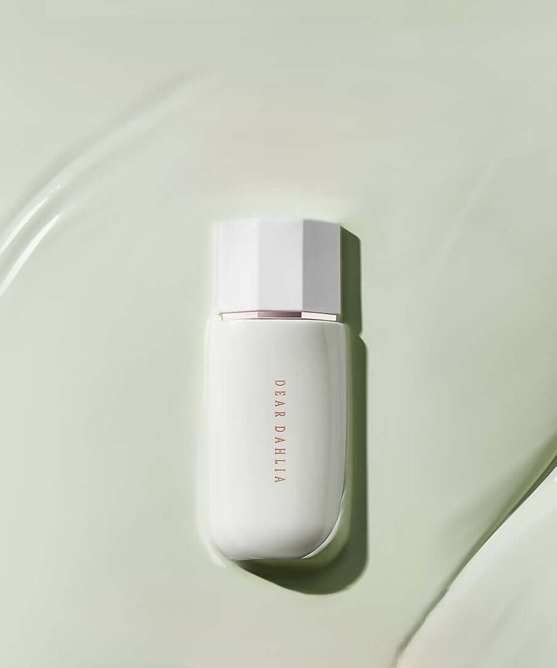Image of DEAR DAHLIA Prime Layer Correcting Primer with elegant packaging on a green background.
