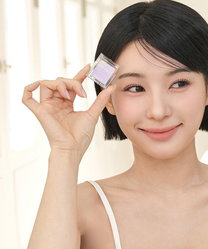 Woman holding DEAR.A Single Concealer 10 Colors smiling indoors