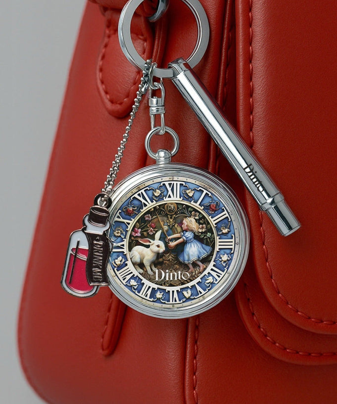 DINTO Alice Collection pocket watch charm on a red handbag, featuring Alice and rabbit design, highlighting the elegant accessory.