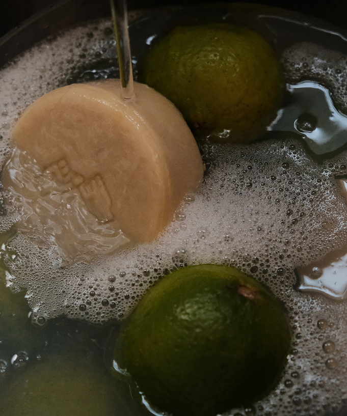 DONGGUBAT Dishwashing Soap Green Tangerine 100g in use with limes in soapy water