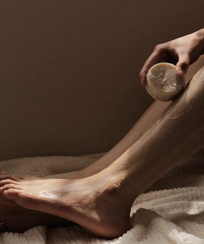 Person using DONGGUBAT Field Correct Body Soap Noni on leg for skincare.